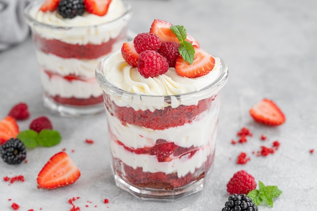 Zuppa di torta di velluto rosso con frutti di bosco freschi in un barattolo di vetro Dessert per lo spazio della copia di San Valentino