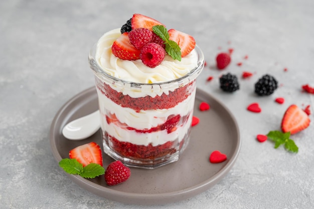 Zuppa di torta di velluto rosso con frutti di bosco freschi in un barattolo di vetro Dessert per San Valentino Copia spazio