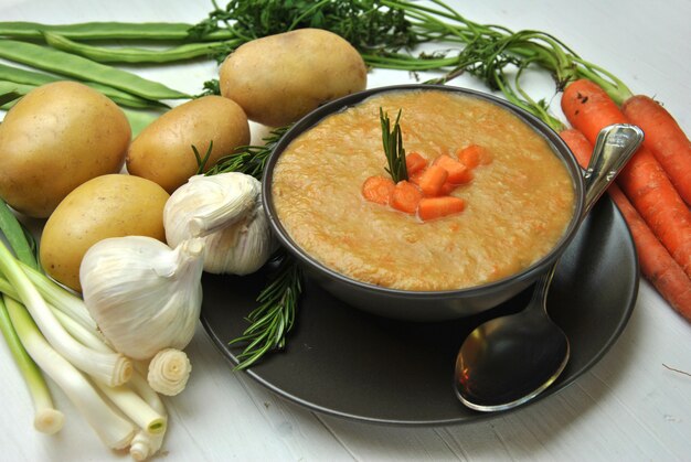 Zuppa di verdure accompagnata con carote, patate e aglio