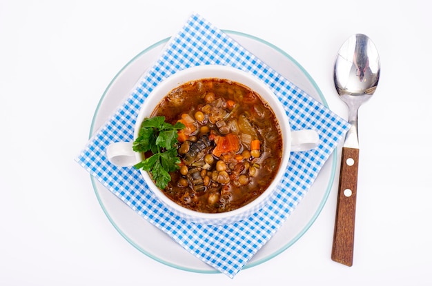 Zuppa di verdure con lenticchie in zolla bianca. Foto in studio