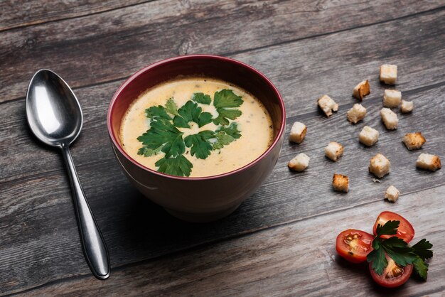 Zuppa di verdure crema di zucca con prezzemolo in una ciotola e un cucchiaio