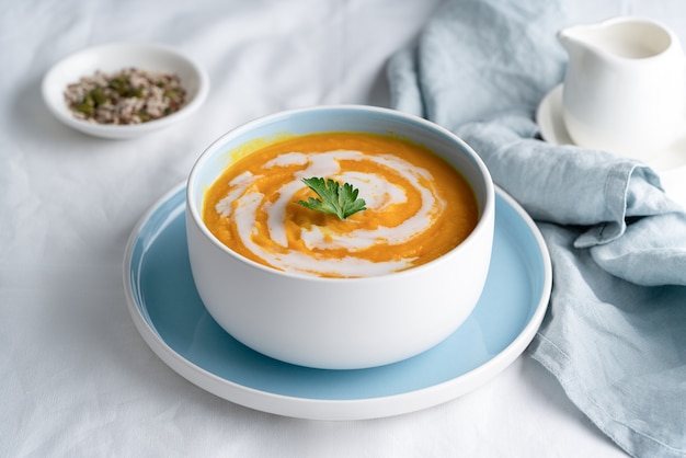 Zuppa di zucca con latte di cocco nella ciotola blu