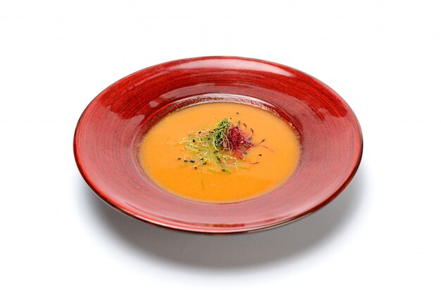 Zuppa di zucca crema in un piatto rosso