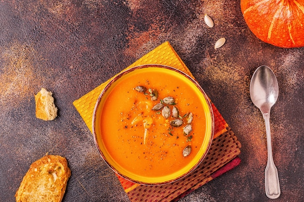 Zuppa di zucca e carote servita con semi, vista dall'alto.