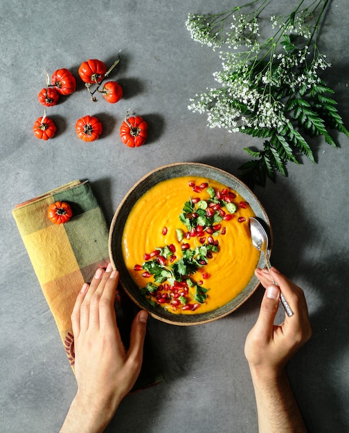 Zuppa di zucca fresca condita con semi di prezzemolo e melograno