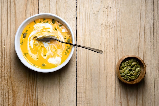 Zuppa di zucca gialla mescolata su sfondo di legno Vista dall'alto Spazio di copia