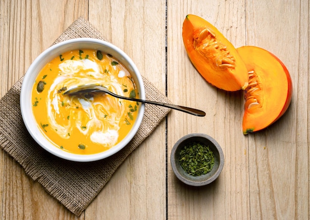 Zuppa di zucca gialla mescolata su sfondo di legno Vista dall'alto Spazio di copia