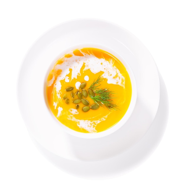 Zuppa di zucca in un piatto bianco su sfondo bianco isolato