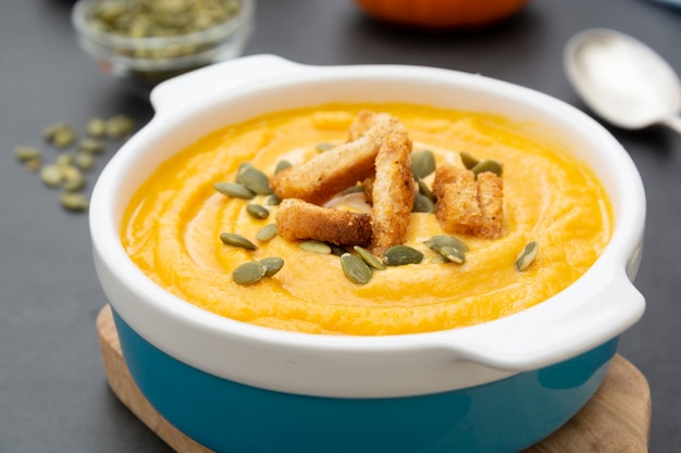 Zuppa di zucca in una ciotola con semi di zucca freschi.