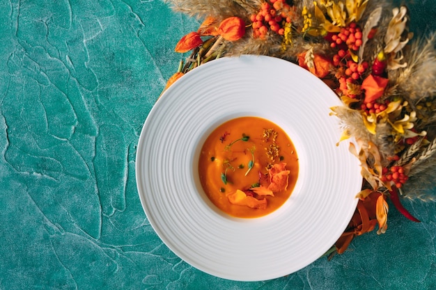 Zuppa di zucca su uno sfondo verde. la vista dall'alto.