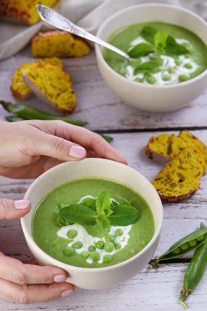 Zuppa fredda di purea di piselli condita con cipolla verde menta e crostini di pane croccante