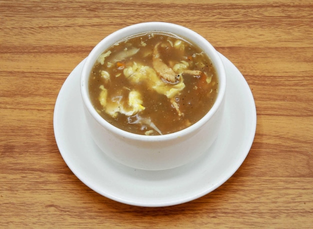 Zuppa fresca calda e acida servita in una ciotola isolata su sfondo grigio vista laterale del cibo indiano pakistano