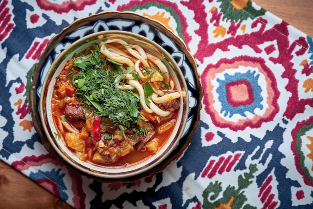 Zuppa Laghman con carne, verdure e spaghetti tirati serviti nel piatto.