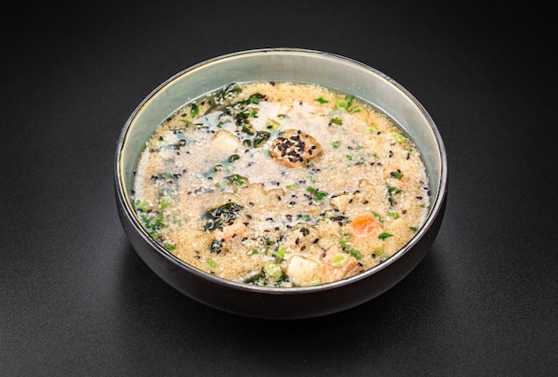 Zuppa ricca di kim chi con trota, tofu. Alghe Wakame, riso, uova di gallina e semi di sesamo.