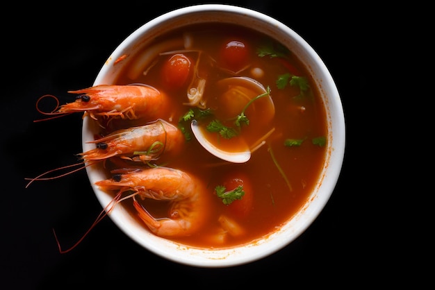 Zuppa tom yum con riso isolato su sfondo nero vista laterale