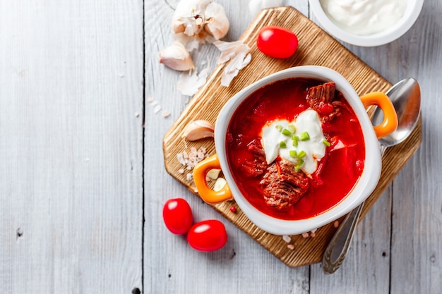 Zuppa tradizionale ucraina e russa di Borsch con carne, barbabietole e cavolo. Zuppa di carne in una ciotola arancione.