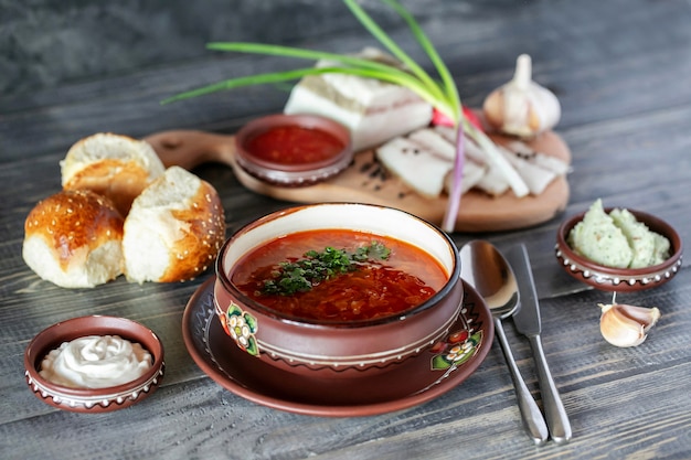 Zuppa ucraina bortchsh. Cucina tradizionale ucraina. Salo wigh aglio cipolla e panini. Panna acida e salse.