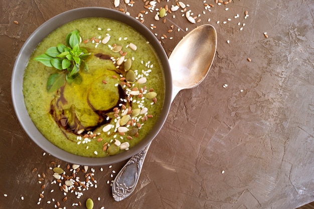 Zuppa vegetariana di verdure verdi su uno sfondo scuro.