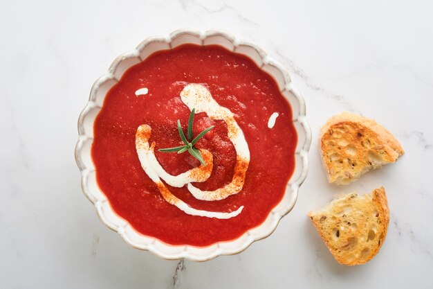 Zuppa Zuppa di crema di pomodoro o gazpacho con erbe condimenti pomodoro ciliegino e prezzemolo in ciotola bianca su sfondo di pietra grigio chiaro zuppa di verdure salutare zuppa fredda spagnola vista superiore con spazio di copia