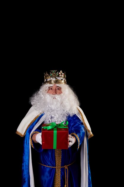 a magician king with a present on a black background