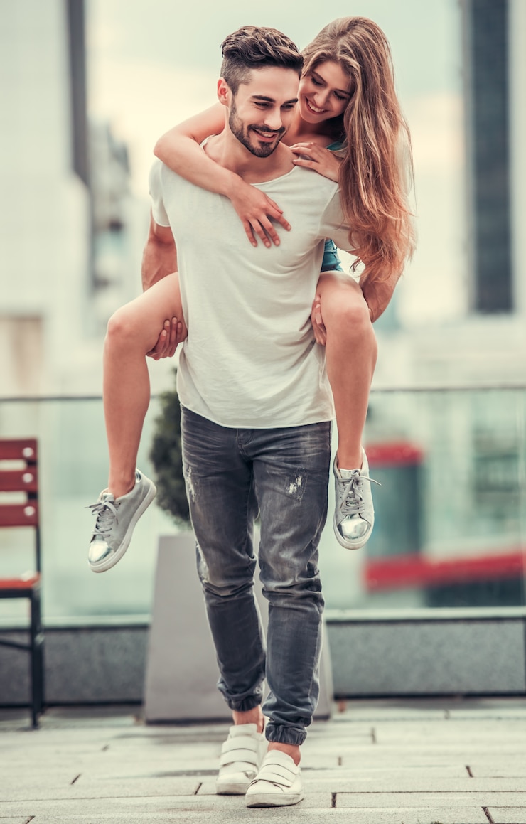 Fotografie a man holds a girl in his arms on the street