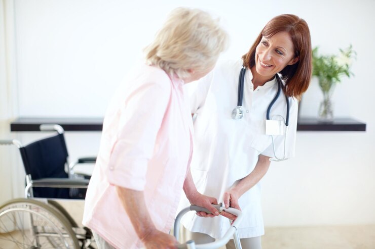 Fotografie a motivating presence for her recovery nurse and elderly patient look at one another while she assists her with a zimmer frame