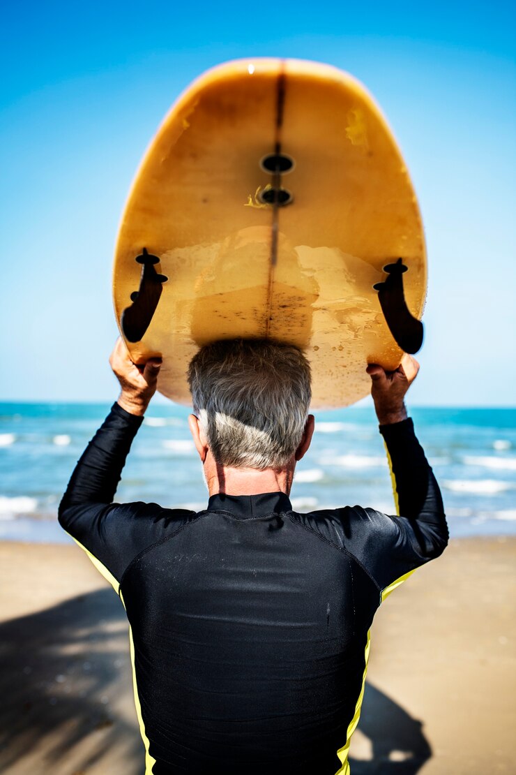 Fotografie a senior man with a surfboard