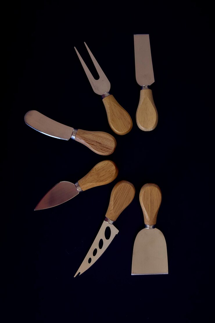 Fotografie a set of fish and cheese knives with a wooden handle on a black background