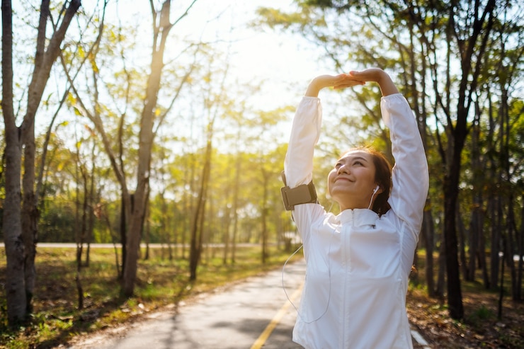 Fotografie a young asian woman do stretching arms before running in city park