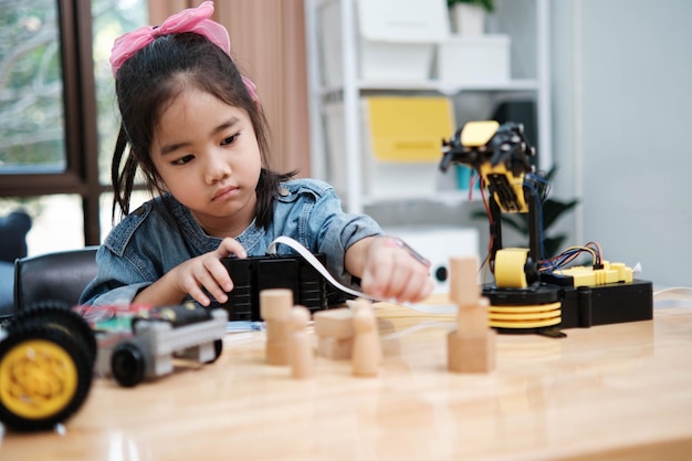 a young girl is playing with a remote control a robot