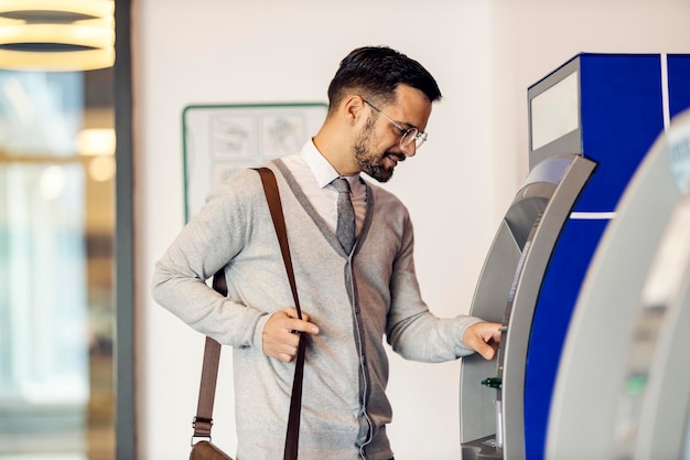 A young man is using ATM at the mall