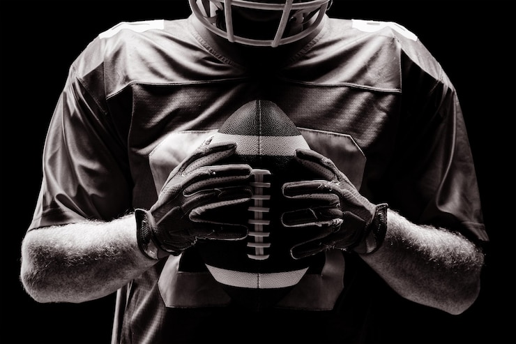 Fotografie american football player holding rugby ball