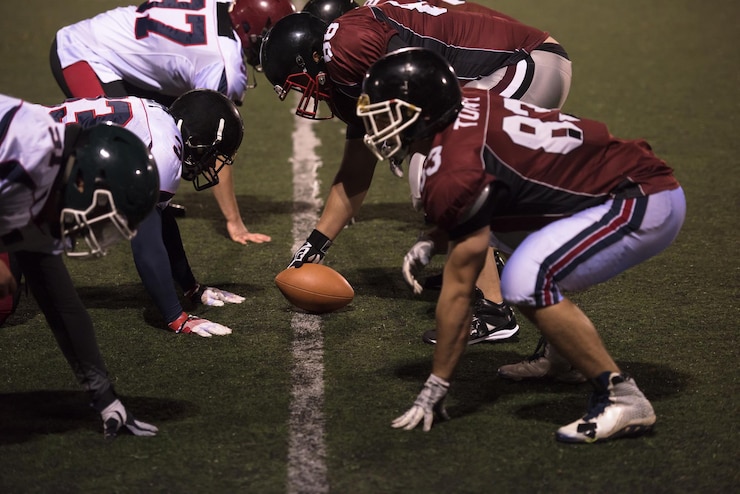 Fotografie american football players are ready to start on field at night