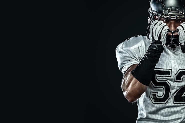 Fotografie american football sportsman player in helmet isolated on black background sport and motivation wallpaper