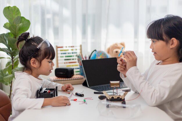 Asia students learn at home in coding robot cars and electronic board cables in STEM STEAM mathematics engineering science technology computer code in robotics for kids concept
