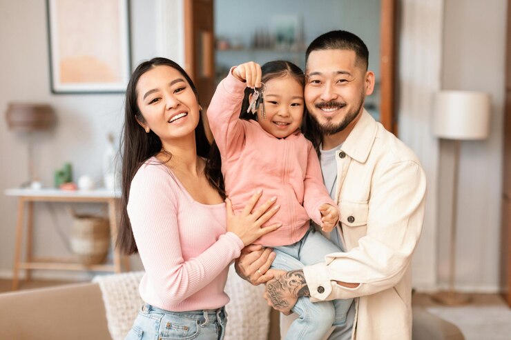 Fotografie asian family with little daughter showing keys and new home