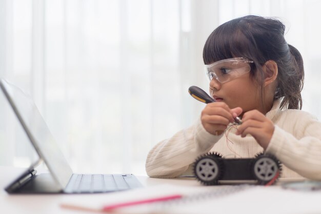 asian students learn at home in coding robot cars and electronic board cables in stem steam mathematics engineering science technology computer code in robotics for kids concept