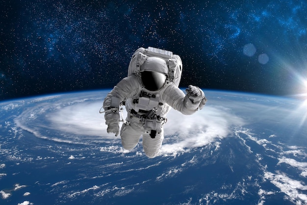 Astronaut in outer open space over the planet Earth.Stars provide the background.erforming a space above planet Earth.Sunrise,sunset.Our home. ISS.Elements of this Image Furnished by NASA.