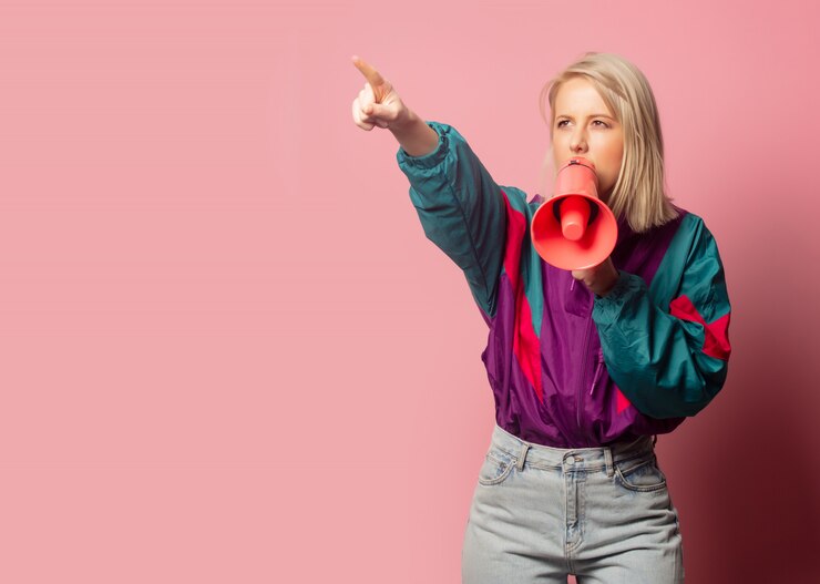 Fotografie beautiful blonde woman in 90s clothes with loudspeaker