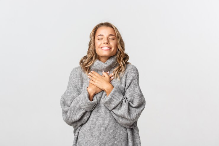 Fotografie beautiful woman in a grey sweater posing