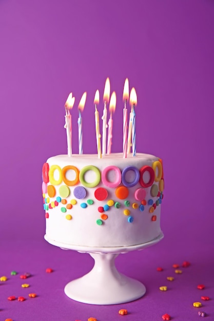 birthday cake with candles on purple background