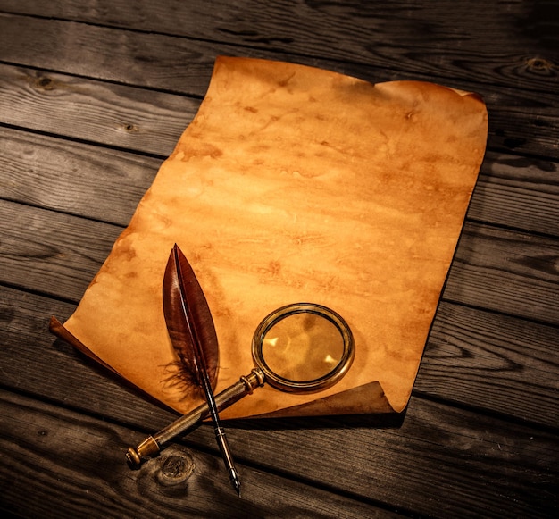 Blank old paper with curled edge against the background of an aged wood