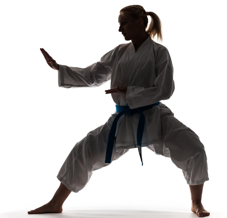 Fotografie blonde hair girl dressed in kimono and posing in karate stand. isolated on white background