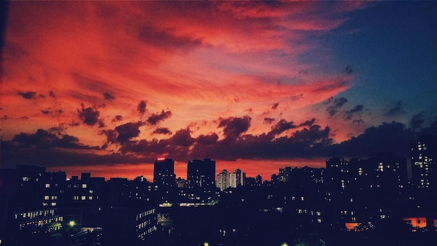 buildings against cloudy orange sky during sunset in city