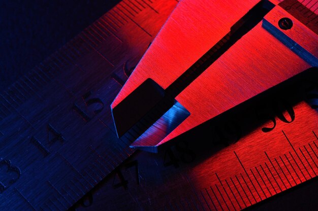 caliper and metal rulers illuminated in red and blue closeup