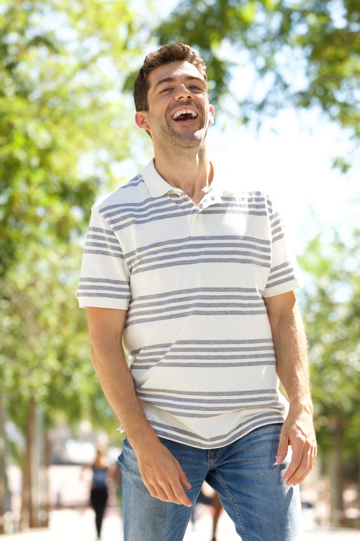Fotografie cheerful young man walking outdoors and laughing