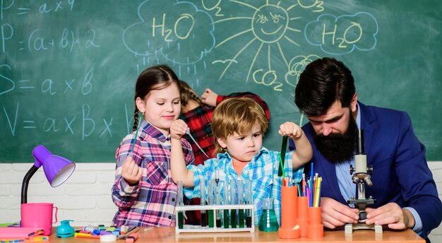 Chemistry themed club Discover and explore properties of substances together Interests and topic club Older kids help younger School club education Teacher and pupils test tubes in classroom