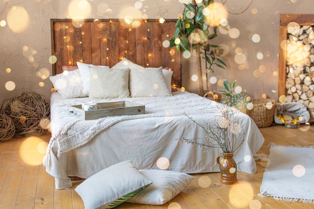 Christmas boho interior design of a cozy bed in the bedroom decorated in Christmas style