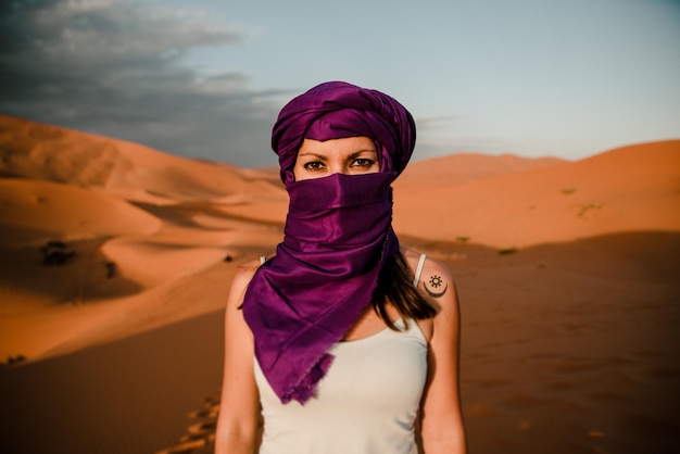close-up of a tourist woman wearing a purple turban looking at camera