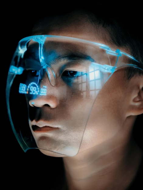 close-up of a young man wearing a face shield at night